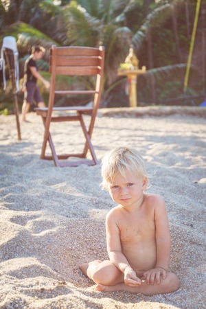 Little angel sitting on a white sand beach in Thailandの写真素材