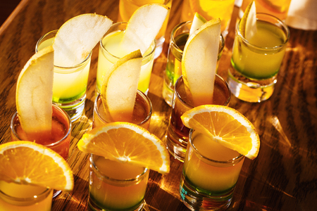 Drink shots and a slice of fresh fruitの写真素材