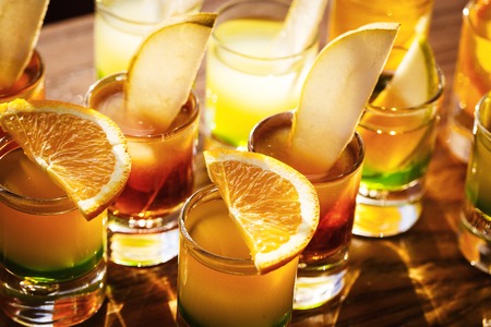 Drink shots and a slice of fresh fruitの写真素材