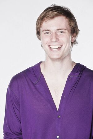 Attractive man in a purple shirt on white backgroundの写真素材