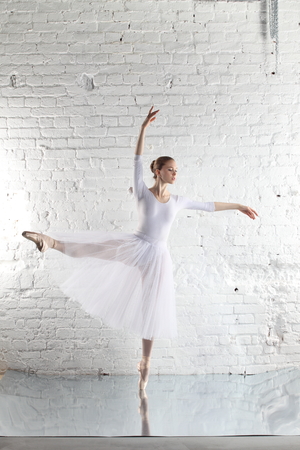 Young ballerina and the white brick wall backgroundの写真素材