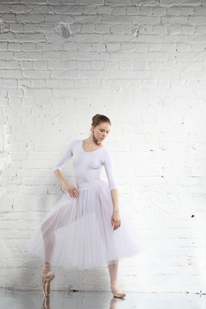 Young ballerina and the white brick wall backgroundの写真素材