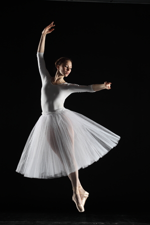 Young ballerina in white on the black backgroundの写真素材