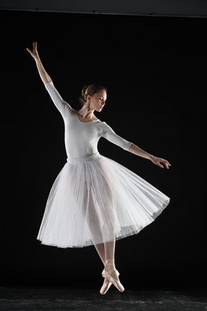 Young ballerina in white on the black backgroundの写真素材