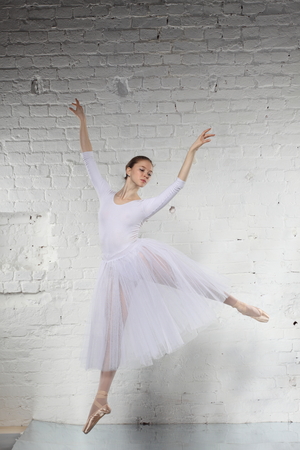 Young ballerina and the white brick wall backgroundの写真素材
