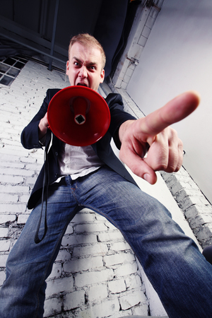 A crazy businessman shouting through a megaphoneの写真素材