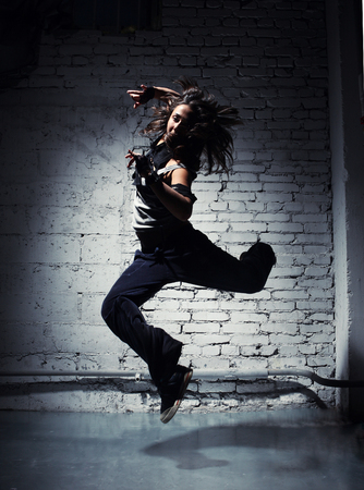 Very beautiful dancer on a background of a grey brick wallの写真素材