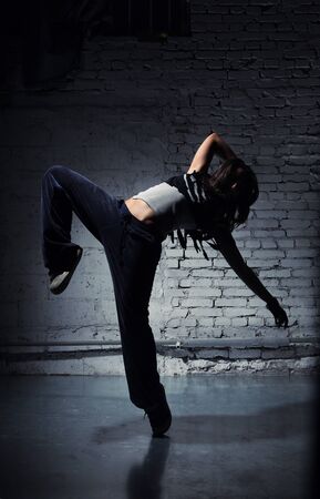 Very beautiful dancer on a background of a grey brick wallの写真素材