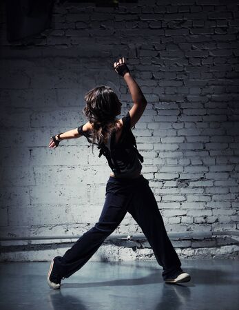 Very beautiful dancer on a background of a grey brick wallの写真素材