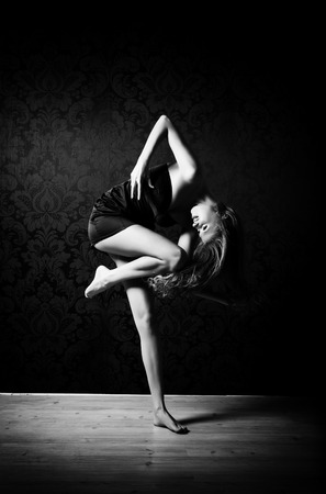 Beautiful girl in black dress on the black backgroundの写真素材