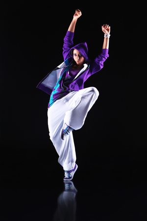 Girl dancer in motion on the black backgroundの写真素材