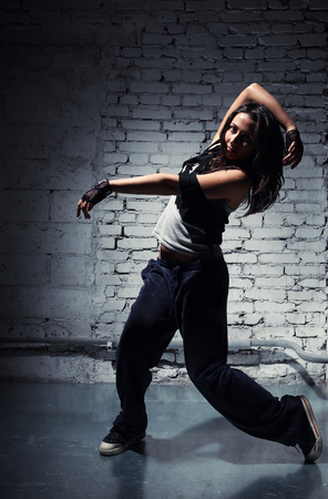 Very beautiful dancer on a background of a grey brick wallの写真素材