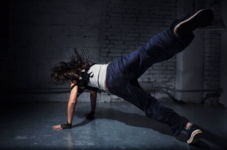 Very beautiful dancer on a background of a grey brick wallの写真素材