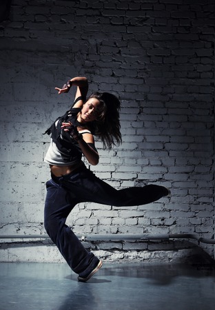 Very beautiful dancer on a background of a grey brick wallの写真素材
