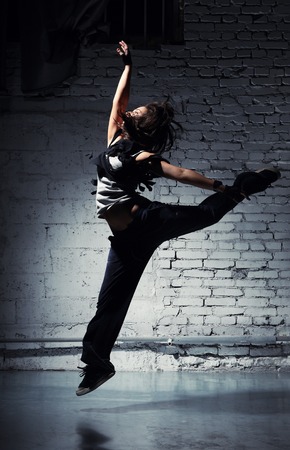 Very beautiful dancer on a background of a grey brick wallの写真素材
