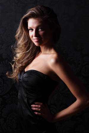 Beautiful girl in black dress on the black backgroundの写真素材