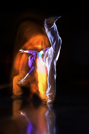 Girl dancer in motion with special light effectの写真素材