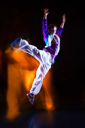 Girl dancer in motion with special light effectの写真素材