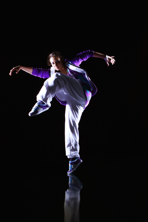 Girl dancer in motion on the black backgroundの写真素材