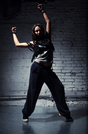 Very beautiful dancer on a background of a grey brick wallの写真素材