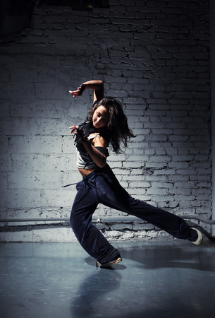 Very beautiful dancer on a background of a grey brick wallの写真素材