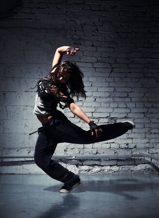 Very beautiful dancer on a background of a grey brick wallの写真素材