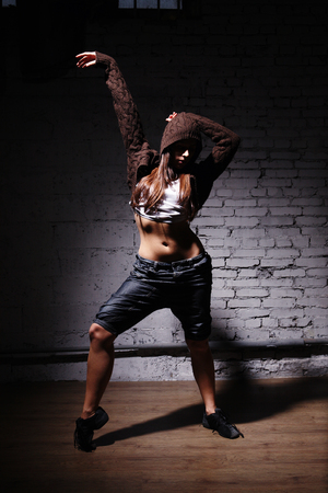 Very beautiful dancer on a background of a grey brick wallの写真素材