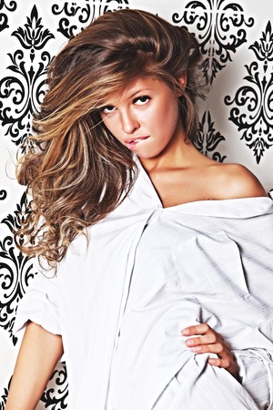 Pretty smiling girl in a white shirt posing for the cameraの写真素材
