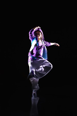 Girl dancer in motion on the black backgroundの写真素材