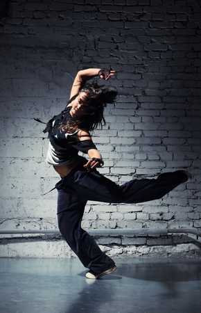 Very beautiful dancer on a background of a grey brick wallの写真素材