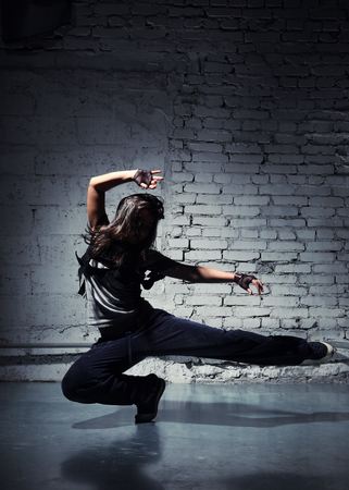 Very beautiful dancer on a background of a grey brick wallの写真素材