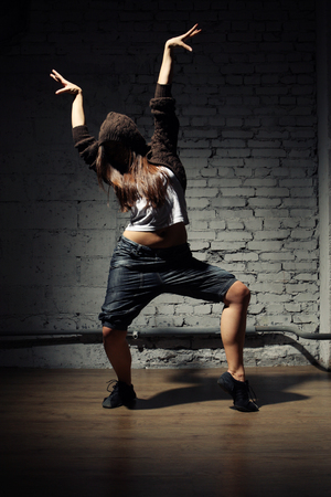Very beautiful dancer on a background of a grey brick wallの写真素材