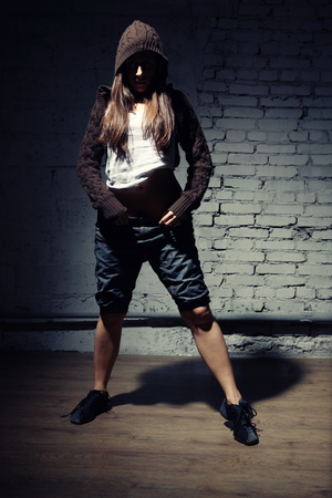 Very beautiful dancer on a background of a grey brick wallの写真素材