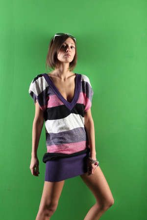 Beautiful girl on green background in striped dressの写真素材