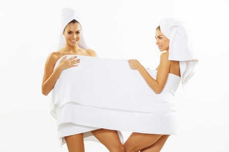 Two happy teen girl after shower in towelsの写真素材