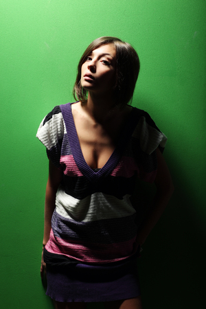 Beautiful girl on green background in striped dressの写真素材