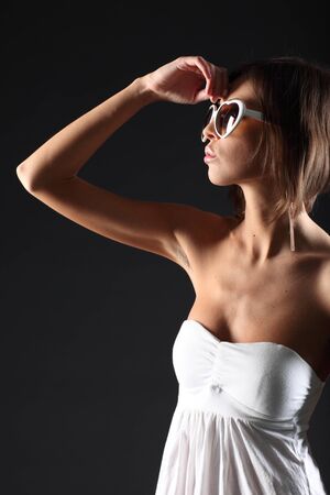 Beautiful girl on black background in white dressの写真素材
