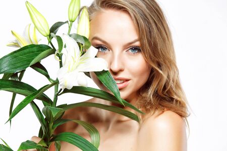 Beautiful girl with white flower isolated on whiteの写真素材