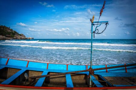 Part of the boat on the shore with blue sea at background