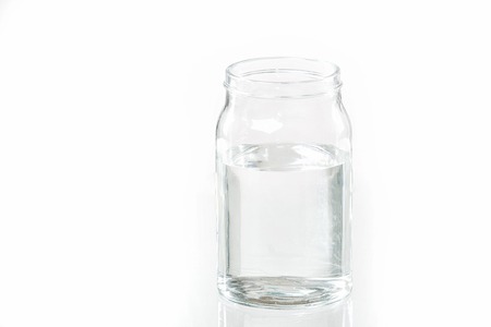 Glass jar with water isolated on white studio shotの写真素材