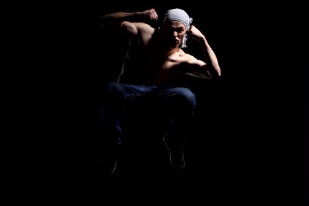 Man in motion on black background studio shotの写真素材