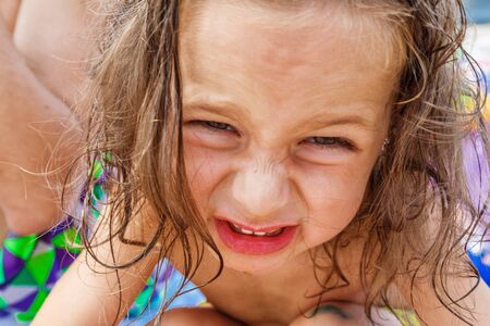 Cute boy eating a peach on the beachの写真素材