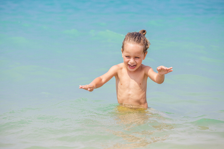 Happy little boy is playing in the seaの写真素材