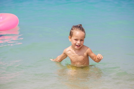 Happy little boy is playing in the seaの写真素材