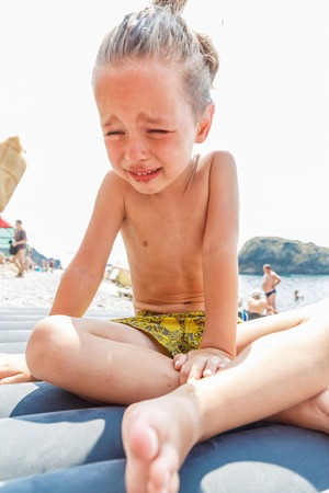 Boy crying on the beachの写真素材