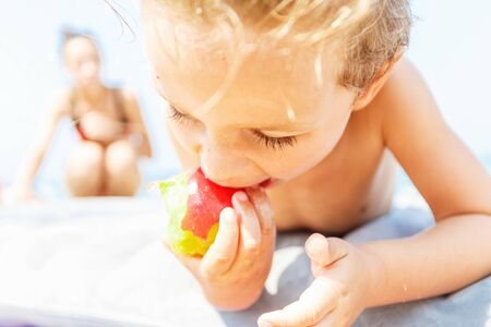 Boy eating a peachの写真素材