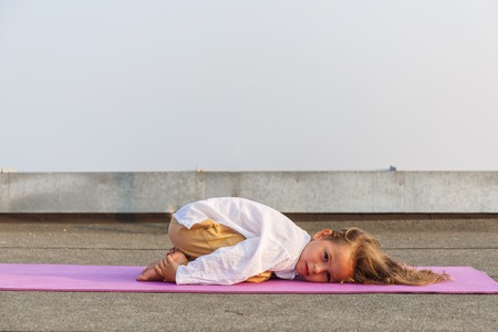 Baby doing yoga on the roofの写真素材