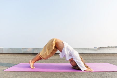 Baby doing yoga on the roof