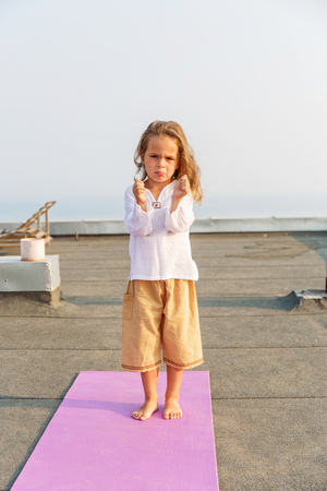 Baby doing yoga on the roofの写真素材