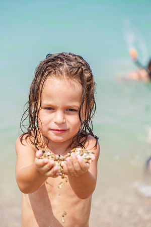 Little boy got pebbles into the handsの写真素材